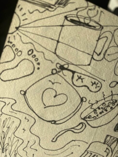 A page with black doodles, including a coffee cup, a pouch with a heart, sunglasses, footprints, and various abstract shapes and lines.