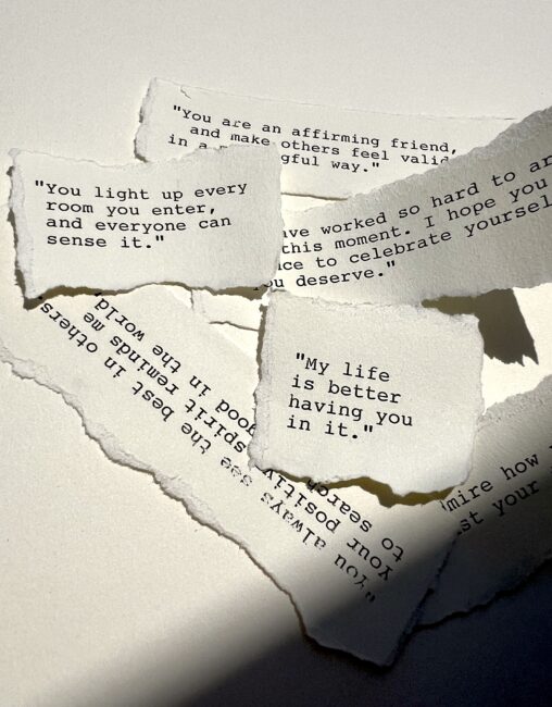 Current image: Torn pieces of paper with heartfelt handwritten messages on a white surface.