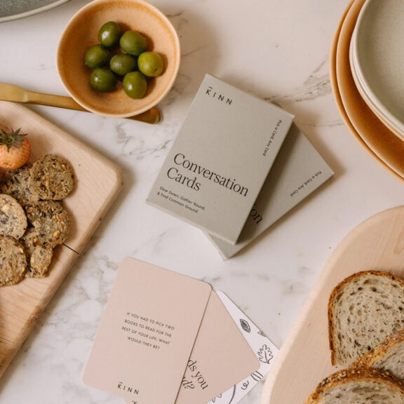 A table with bread, olives, and cards on it.