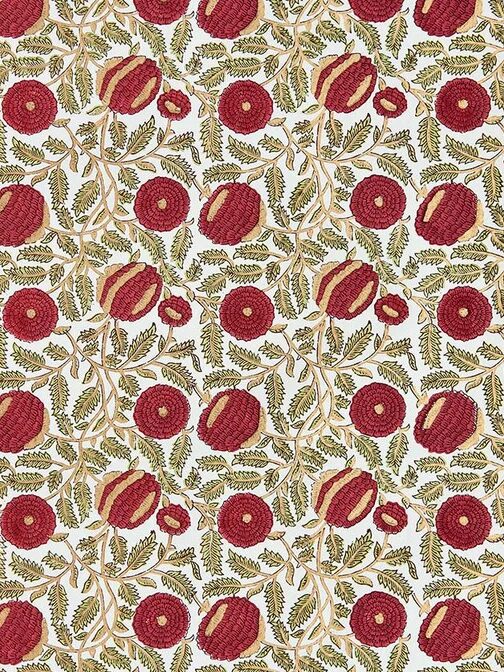 Patterned textile featuring repeating red pomegranate motifs and green leaves on a white background.