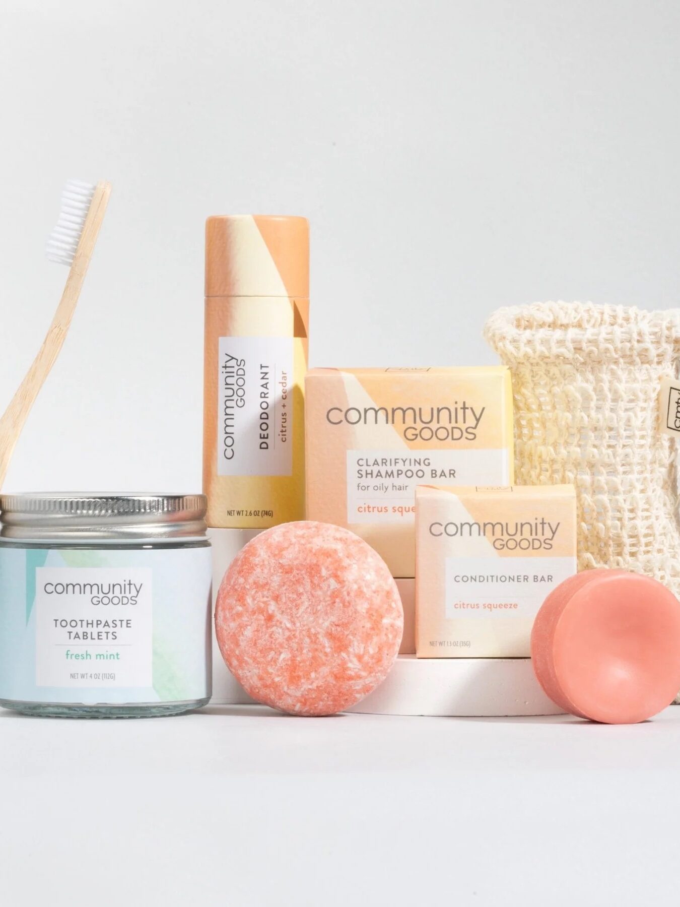 Toiletry set with a bamboo toothbrush, toothpaste tablets, deodorant, shampoo and conditioner bars, soap bag, and soap. Packaged in eco-friendly materials.