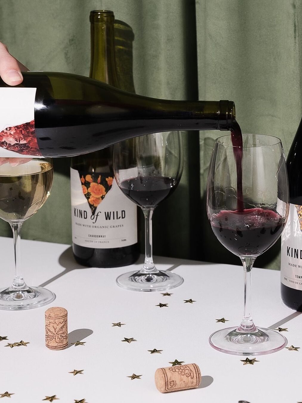 A bottle of Kind of Wild wine being poured into a glass.