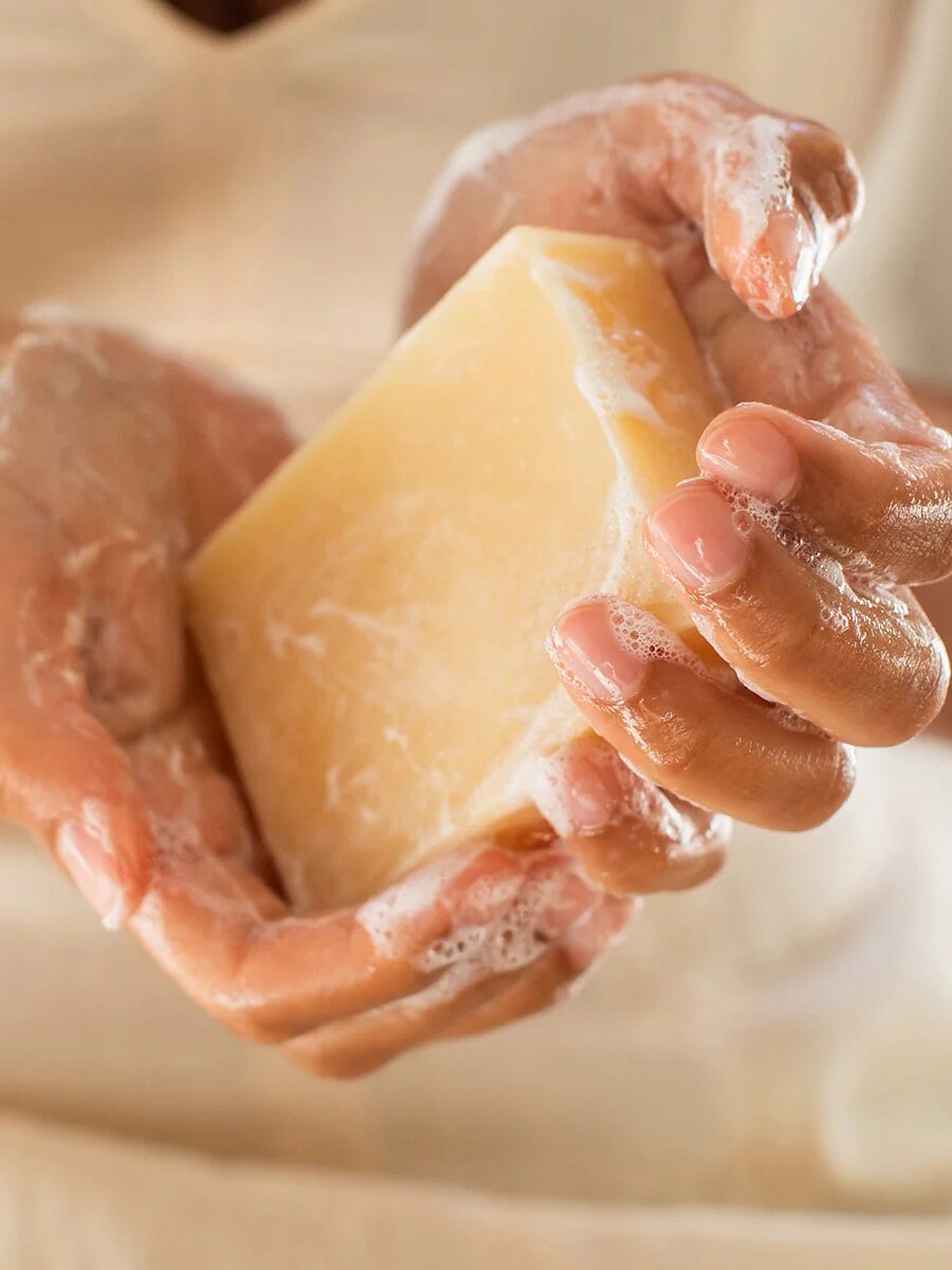 Hands lathering a bar of Meow Meow Tweet soap.
