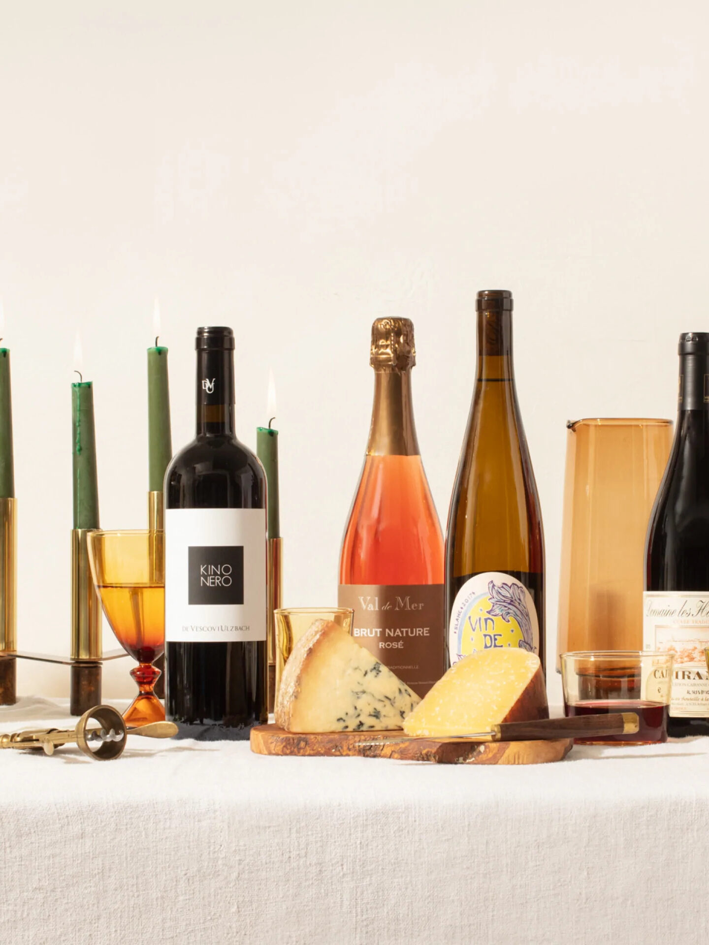 A tablescape of snacks, candles, wine bottles, and more.