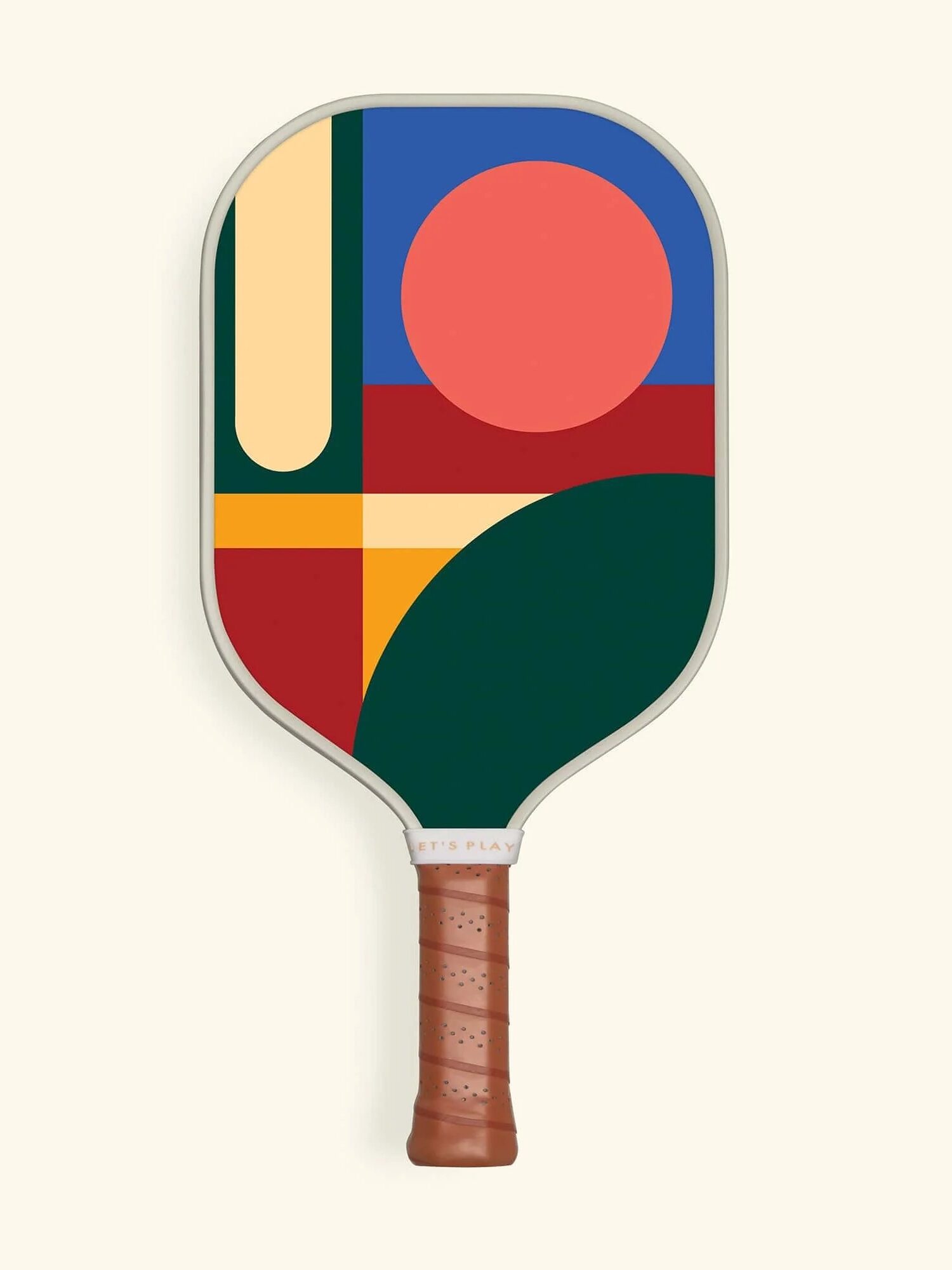 A pickleball paddle with a geometric abstract design in red, green, blue, yellow, and cream, featuring a brown leather grip.