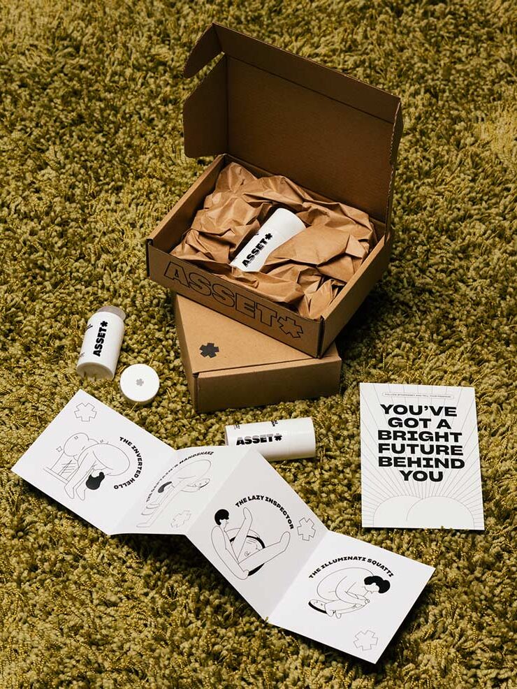 A cardboard box on a green carpet contains skincare product containers, an illustrated booklet, and a card that says, “YOU’VE GOT A BRIGHT FUTURE BEHIND YOU.”.