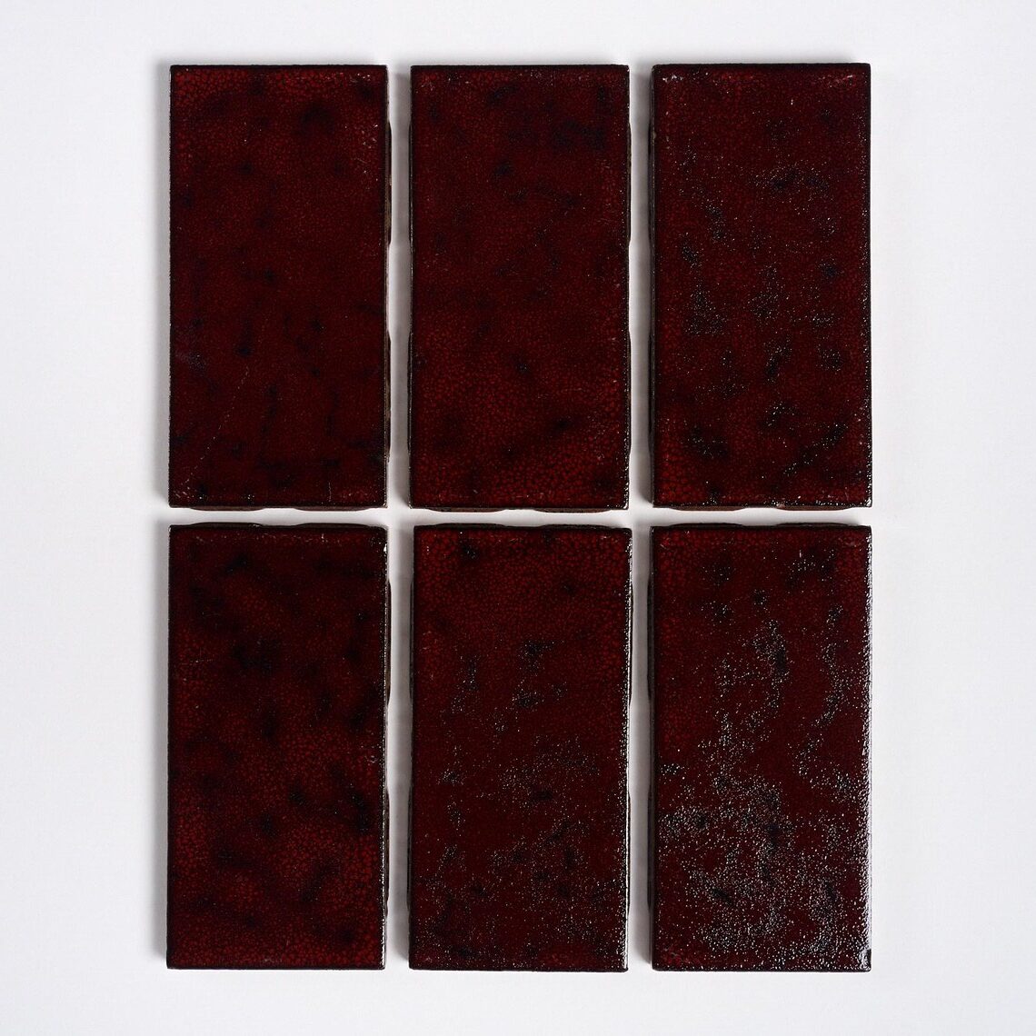 Six dark red rectangular tiles arranged in two rows against a white background.