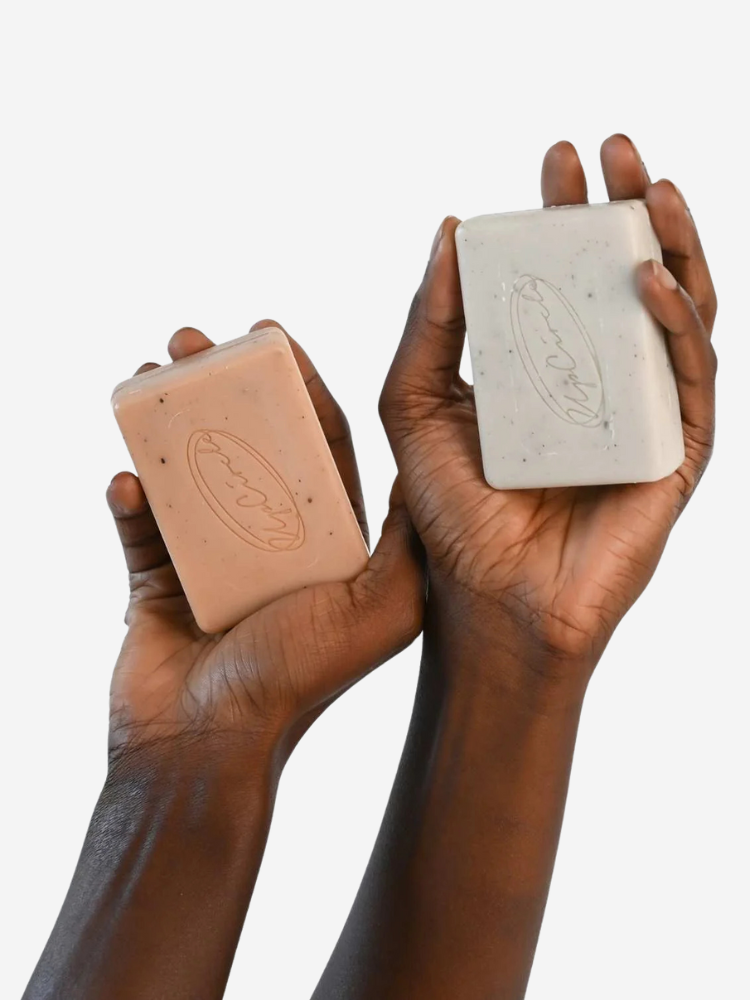 A pair of hands holding up two bars of Upcircle Beauty soap.