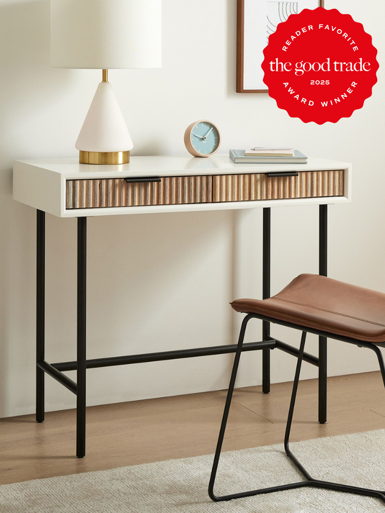 A small desk with a lamp, clock, and a chair next to it. A red "Reader Favorite Award Winner" badge from The Good Trade is displayed in the corner.
