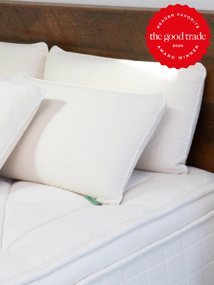 White pillows and a mattress with a wooden headboard. A red badge in the top right corner reads "the good trade 2025 award winner.