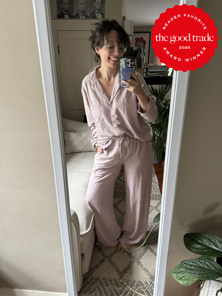 A person taking a mirror selfie in a cozy room, wearing light pink pajamas. A "Reader Favorite" badge from The Good Trade is displayed on the image.